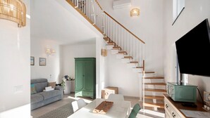 A modern living space with a staircase, a dining area, and a green cabinet. - Apartment 'Agriturismo Le Pale - Giuli 2' with Sea View, Wi-Fi and Air Conditioning (Bogliasco)