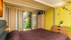 A bedroom with a bed, a dresser, a nightstand, a window with curtains, and a balcony. - Apartment 'La Dimora Di Via Manzoni' with Private Terrace, Wi-Fi and Air Conditioning (Catania)