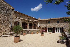 A courtyard with stone buildings, potted plants, and a clear blue sky. - La Buisse - Les 2 Gites: Mountain View, Shared Terrace & Wi-Fi (Simiane-la-Rotonde)