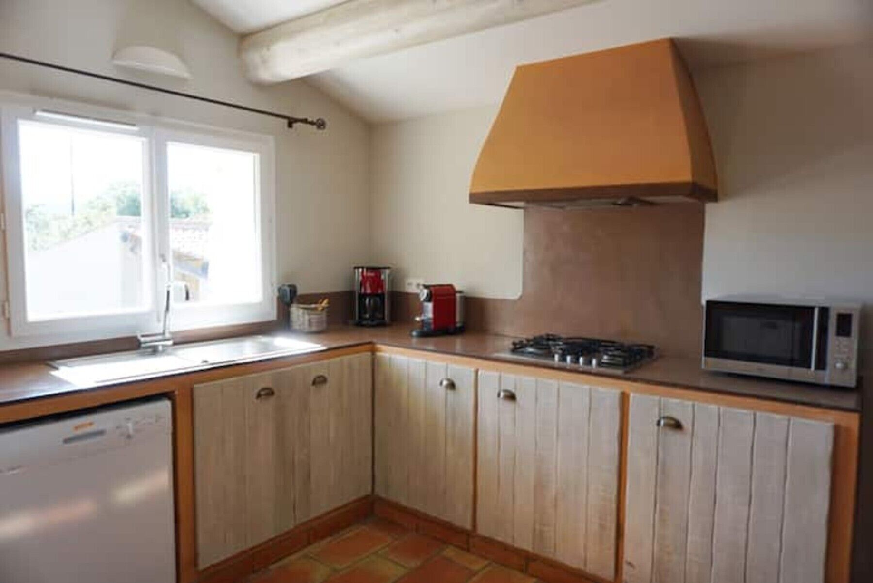 Cocina equipada con lavavajillas, estufa, microondas y ventana con vistas.