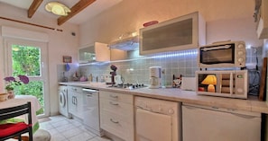 A kitchen with white appliances, a gas stove, a coffee maker, and a microwave.