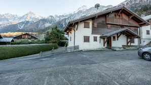 Eine Berglodge mit Holzhülle, einer überdachten Veranda und Blick auf schneebedeckte Berge.