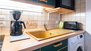 Eine Küche mit Kaffeemaschine, Toaster und Waschmaschine.