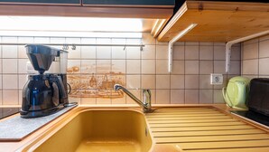 Eine Küche mit Spüle, Kaffeemaschine und Wasserkocher.