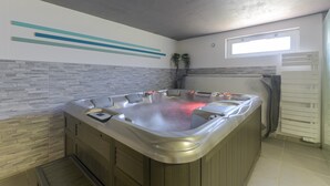 Un baño moderno con una bañera independiente, un ventanal y un revestimiento de pared de piedra.