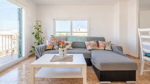 A modern living room with a sofa, a coffee table, and a plant. - Apartment 'Wonderful' with Sea View, Wi-Fi and Air Conditioning (Can Picafort)