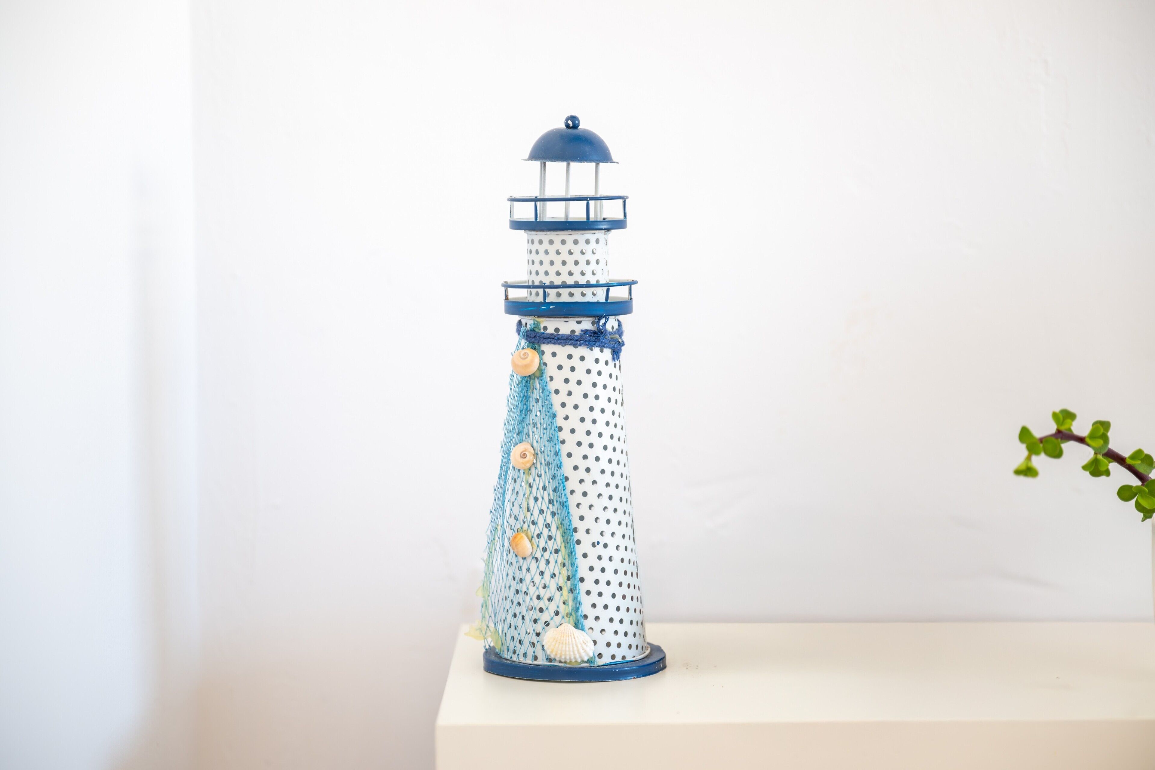 Un modelo de faro con la parte superior azul, el cuerpo blanco y detalles azules.