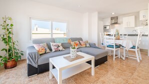 A modern living room with a sofa, coffee table, and a dining area with chairs and a table. - Apartment 'Wonderful' with Sea View, Wi-Fi and Air Conditioning (Can Picafort)