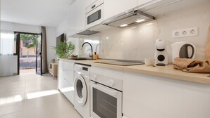 A modern kitchen with built-in appliances, a washing machine, and a coffee maker.