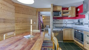 A compact kitchen with wooden cabinets, a microwave, and a sink.
