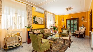 A living room with a sofa, chairs, a coffee table, and a decorative cart. - Villa 'Villetta Mare E Monti' with Sea View, Wi-Fi and Air Conditioning (Mascali)