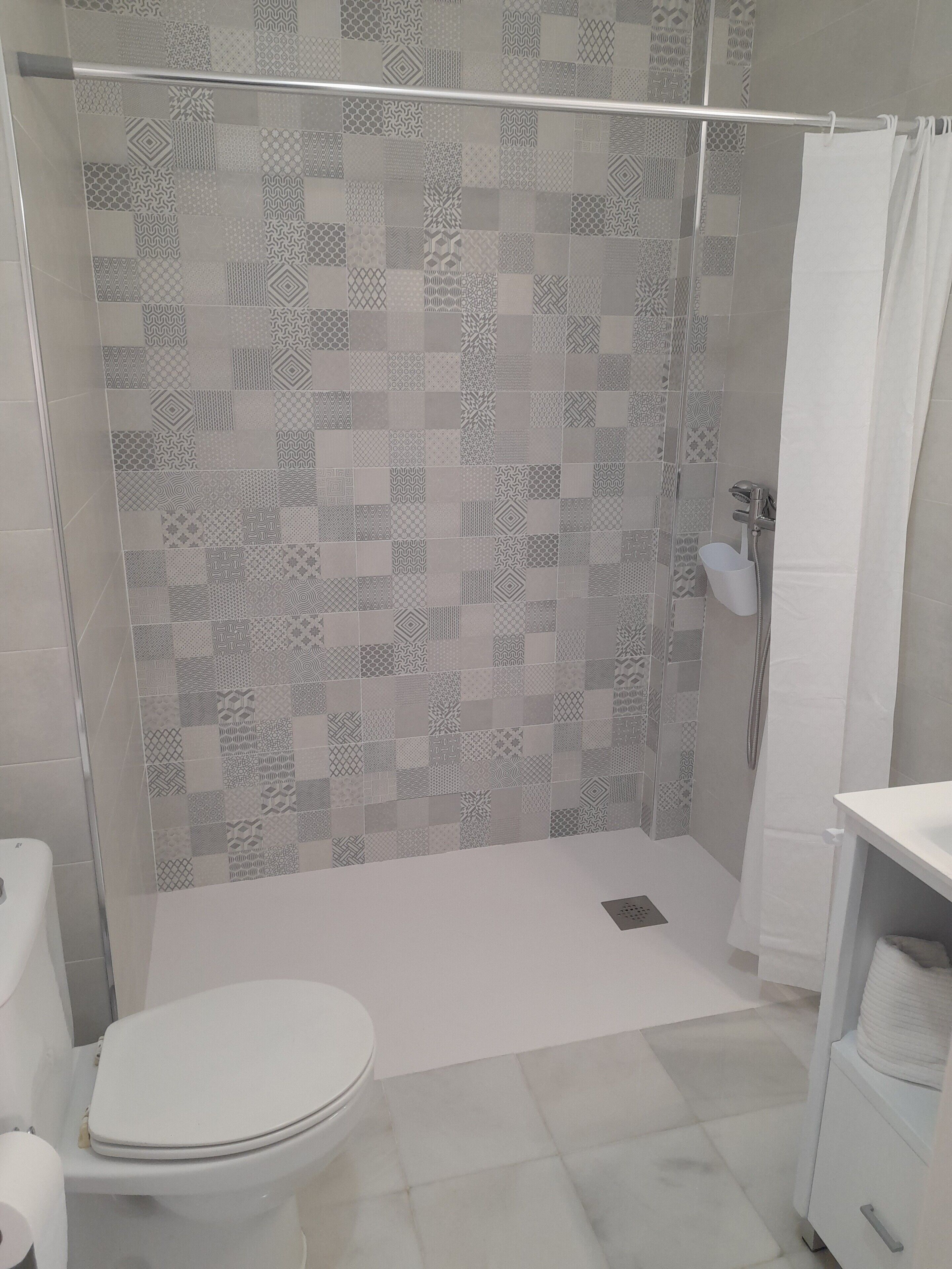 Un baño con ducha, inodoro y lavabo.