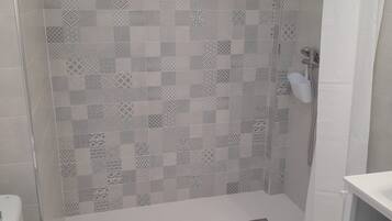 Un baño con ducha, inodoro y lavabo.