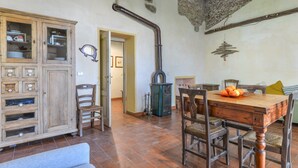 Une cuisine rustique avec un meuble en bois, une cuisinière et une table à manger entourée de chaises.