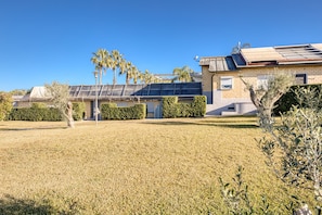 Un bâtiment moderne doté d’un toit plat, de panneaux solaires et d’une pelouse bien entretenue.