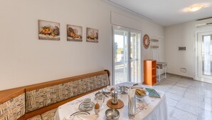 A dining area with a table set for breakfast, a bench with patterned cushions, and wall-mounted artwork.