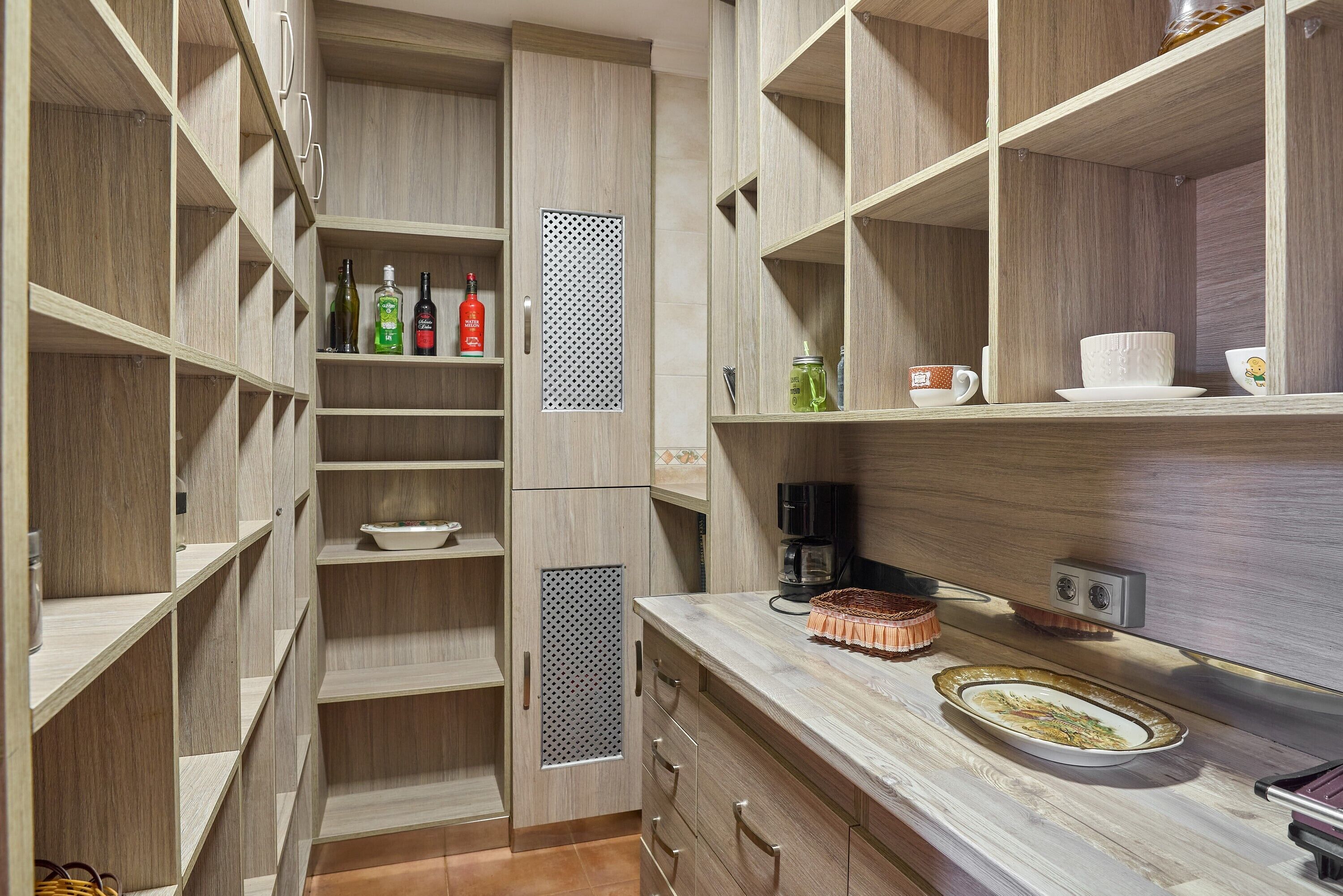 Una cocina moderna con armarios de madera, encimera de mármol y una cafetera.