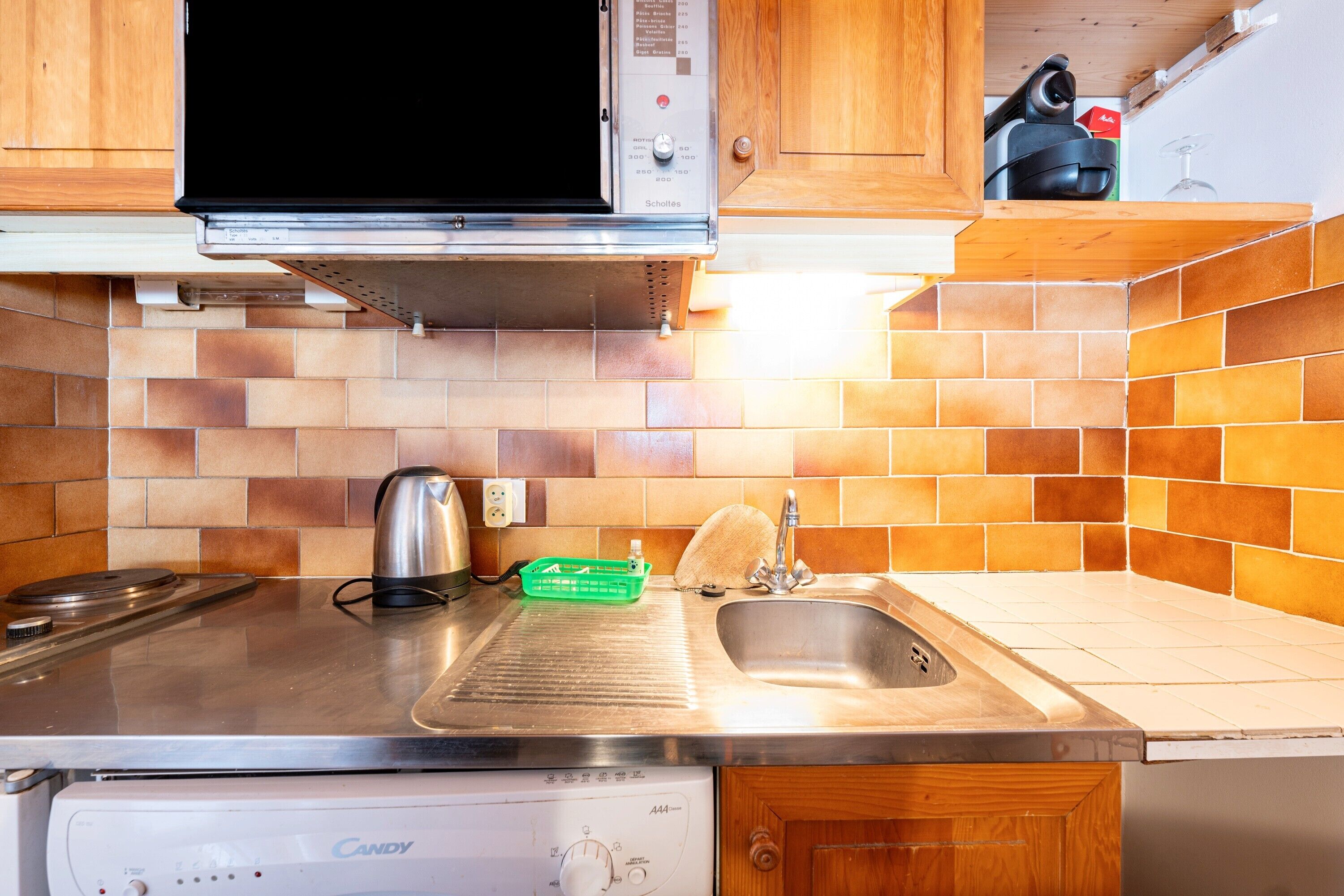 Une cuisine équipée d’un four à micro-ondes, d’une cuisinière, d’un évier et d’un lave-vaisselle.