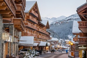 A wooden building with balconies, a sign for 'boka', and a sign for 'ROSSIGNOL'.