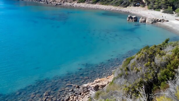 A coastal landscape with clear blue water, rocky shore, and a hill with sparse vegetation. - Apartment 'Trilocale Bonalaccia 2' with Shared Pool, Private Terrace and Wi-Fi (Campo nell'Elba)