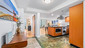 Una cocina moderna con una isla central, horno empotrado y electrodomésticos de acero inoxidable.