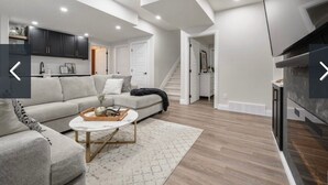 A modern living room with a sofa, coffee table, and fireplace. - Charming 2-bedroom house in awesome Edmonton with AC, WiFi (Edmonton)