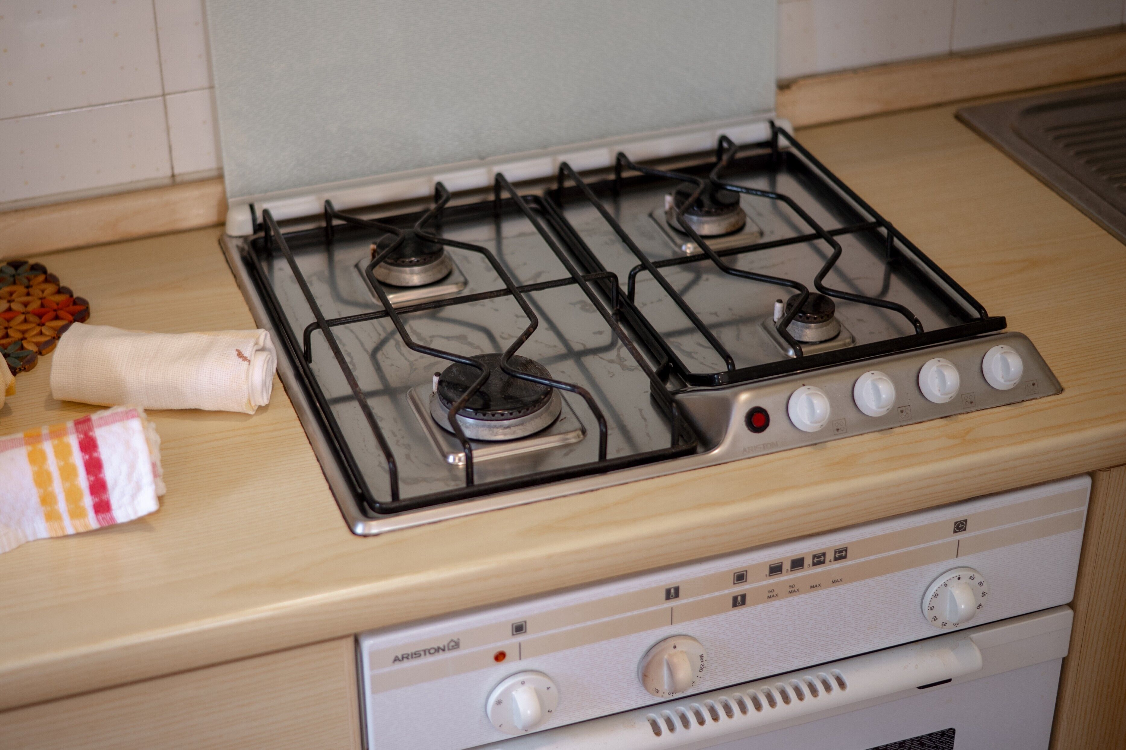 A kitchen with a gas stove, oven, and a towel on the counter.
