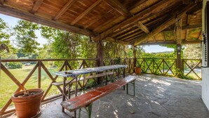 A covered outdoor area with a wooden bench, picnic table, and potted plants. - Room 'Camera Sud' with Shared Pool, Shared Terrace and Wi-Fi (Sorano)