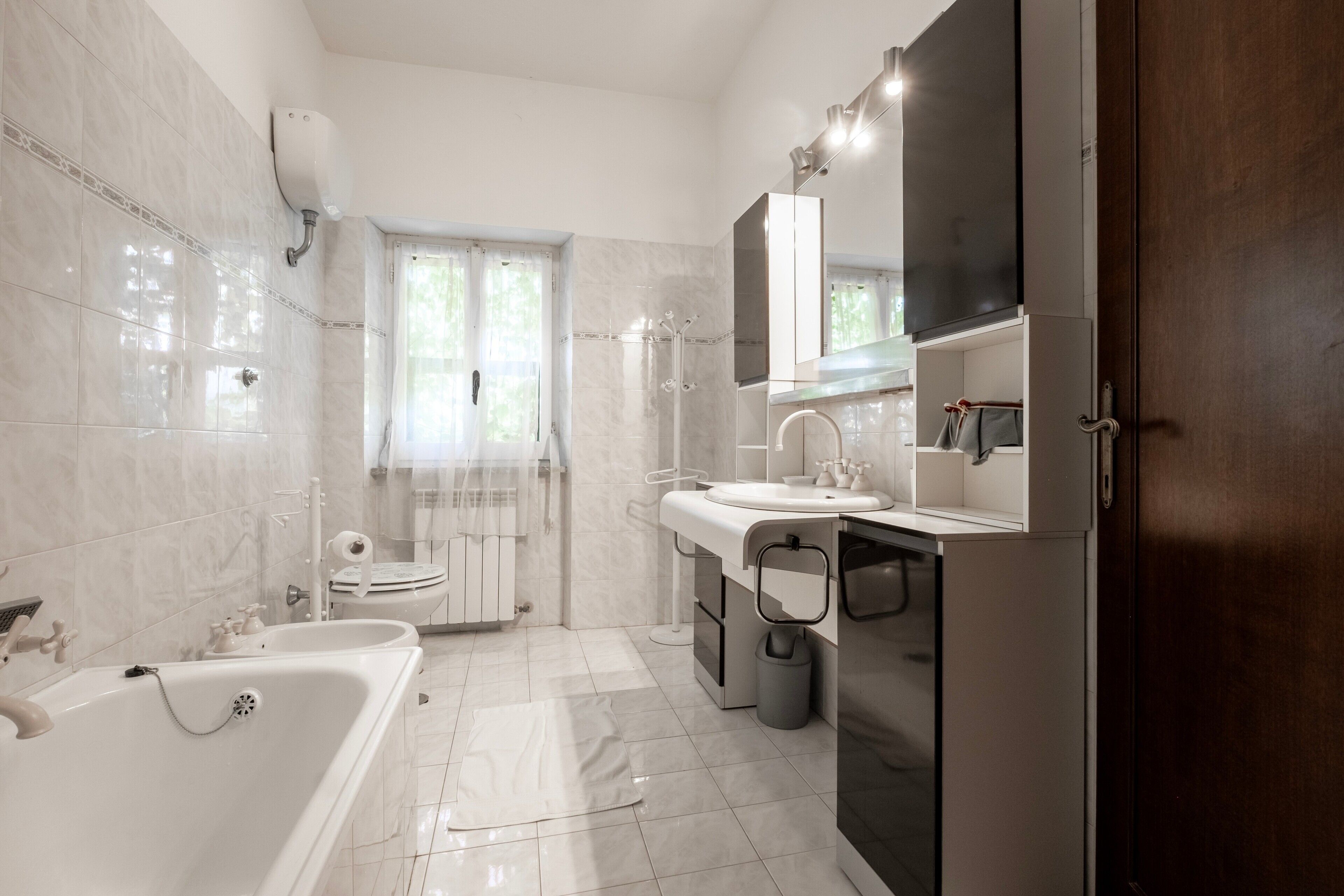 Une salle de bain moderne équipée d’une baignoire, de toilettes et d’un meuble-lavabo.