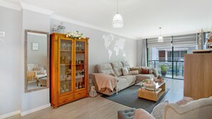 A living room with a large wooden cabinet, a sofa, a coffee table, and a world map on the wall.