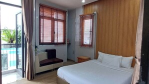 Un dormitorio con una cama grande, un sofá y una ventana con persianas.