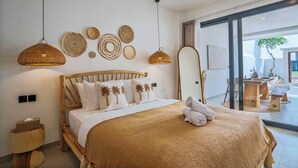 Quarto moderno com cama de madeira, um espelho grande e vista para o pátio externo.