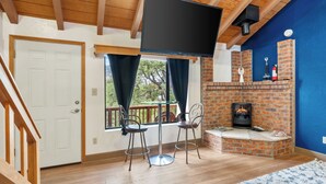 A room with a brick fireplace, a TV mounted on the wall, and a wooden ceiling. - Charming 3-bedroom house with WiFi, AC, in pleasant Williamson Valley, Prescott (Prescott)