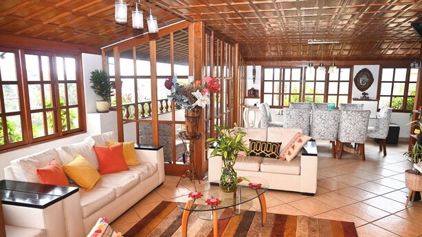 A spacious living area with a sofa, coffee table, and patterned chairs.