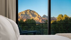 Ein Schlafzimmer mit einem großen Fenster und Blick auf die Berge.