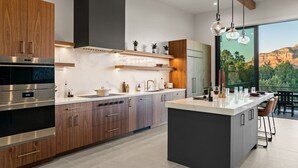 Eine moderne Küche mit Holzausziehtüren, Edelstahlgeräten und einer großen Kochinsel.