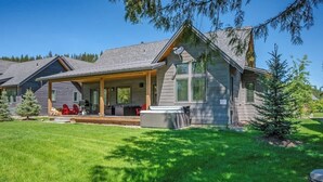 A modern house with a covered porch, a hot tub, and a well-maintained lawn. - Idaho Club Golf Course | Luxe Living & Hot Tub (Sandpoint)