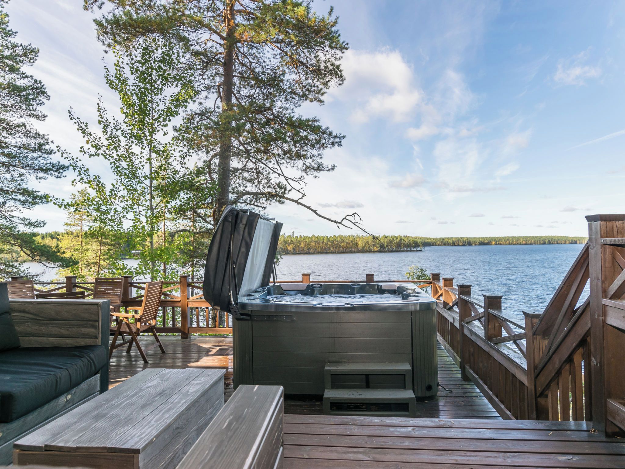 Lämminvesiallas puukannella, jolta avautuu näkymä järvelle ja metsään.