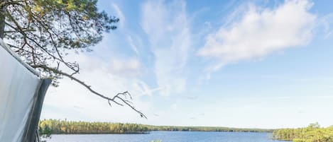 Un bain à remous avec une terrasse en bois et vue sur un lac.