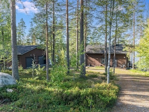 A cabin with a dirt path leading to it, surrounded by tall trees and dense underbrush. - Nuottarinne by Interhome (Keuruu)
