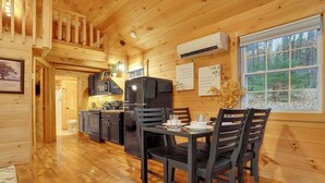 A wooden cabin interior with a kitchen and dining area. - Romantic Getaway | Hot Tub, Fire Pit, Ping Pong (Richfield)