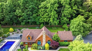 A large house with a swimming pool, surrounded by lush greenery. - Perfect for couples, families, or small groups, this retreat blends serenity with style for an unforgettable getaway. Plenty of amenities to keep the family entertained indoors and out! (Mount Pleasant Mills)