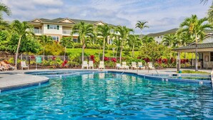 Ein Swimmingpool mit Liegestühlen und Palmen.