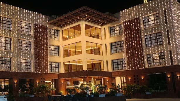 A hotel with a central courtyard, multiple floors, and a modern architectural design. - The Pramukh Hotel (Sinor)