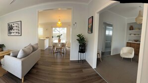 Un salon moderne avec un canapé, une table à manger et une cuisine en arrière-plan.