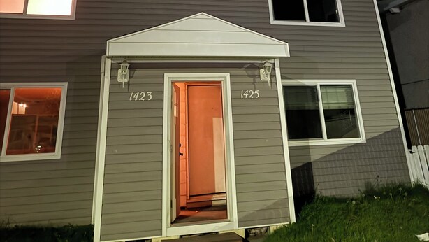 A two-story house with a visible number '1423' on the front door.