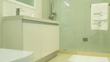 Ein modernes Badezimmer mit Duschkabine aus Glas, einem weißen Waschbecken und einem großen Spiegel.