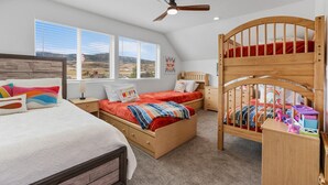 Un dormitorio con una cama individual, una litera y un escritorio.