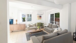 A modern living room with a sofa set, a coffee table, and a TV. - Protaras Blue River Villa Br26 (Περνέρα)