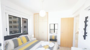 A modern hotel room with a large bed, a wardrobe, a bathroom, and a view of the outside. - Protaras Blue River Villa Br26 (Περνέρα)
